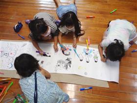 大きなお絵かきをして遊ぶこどもたち