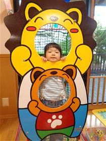 遊具の穴から顔を出して遊ぶ男の子