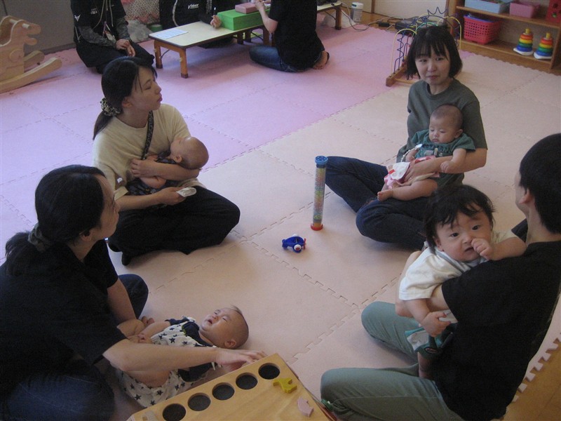 広場でおしゃべりをしているママ達の写真